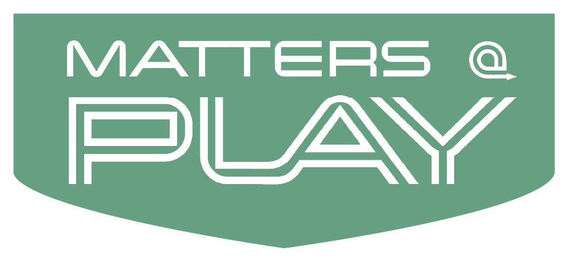 Matters at Play lab's logo is a downward pointing shield with typographic words Matters and Play with a styled at symbol with an arrow flourish